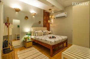 a small bedroom with a bed and a mirror at EKOSTAY - Copacabana Villa in North goa
