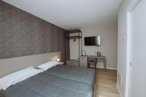 une chambre avec un grand lit et un bureau dans l'établissement Locanda Madonna di sotto, à Sassuolo