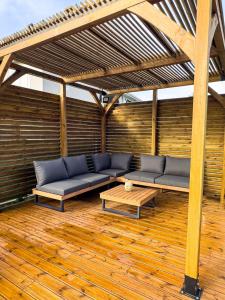 a patio with a couch and a table on a wooden floor at Evasion tropical in Les Trois-Îlets