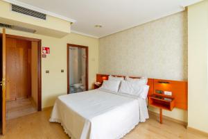 a bedroom with a large white bed with white pillows at Motel Venecia in Taboadela +15 photos