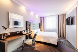 a hotel room with a bed and a desk at Premier Inn Hamburg City Millerntor in Hamburg