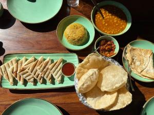une table avec des assiettes de nourriture avec du pain et des trempettes dans l'établissement Rigzin House by Meghsparsh Resorts, à Palchān 21 autres photos