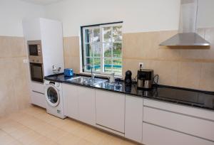 a kitchen with a sink and a washing machine at Casa Belavista no Geres by In'Canto Property Management in Ponte da Barca