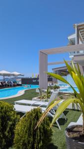 a row of white lounge chairs next to a swimming pool at Crystal Blue in Potos