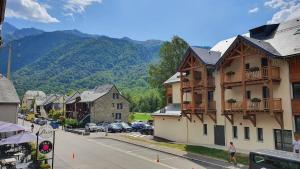 a street in a small town with a mountain at Beau logement 5 pers, proche de toutes commodités in Loudenvielle