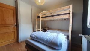 a bedroom with two bunk beds and a door at Beau logement 5 pers, proche de toutes commodités in Loudenvielle