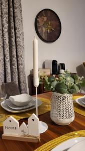a dining room table with a candle and a clock at Deluxe Apartment Waldbröl in Waldbröl +8 photos