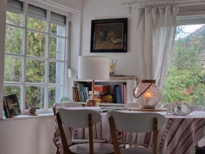 a dining room with a table and two windows at Porta in Bálványos