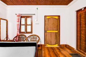 a room with a door and a table and chairs at Hotel O Chilapata Forest Formerly Moner Manush Homestay in Uttar Simlabari