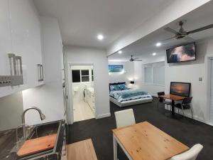 a room with a bed and a table and a kitchen at Luxury Resort Studio Apartment Retreat with Pool, Tennis & Alfresco 