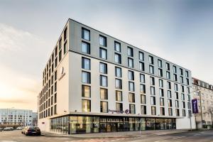 a large white building with windows on a street at Premier Inn Leipzig City Hahnekamm in Leipzig