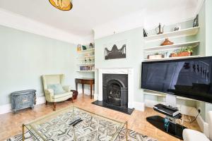 Una sala de estar con chimenea y un televisor de pantalla grande. en Chic House With Free Parking and Private Backyard, en Harrow 26 fotos más