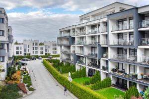 ein Mehrfamilienhaus mit einem Garten davor in der Unterkunft Szyndzielnia Park no 26 # kortem tenisowym, rowerownią # Nestapartamenty in Bielsko-Biała