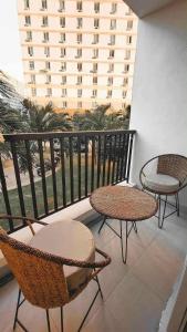 a balcony with two chairs and two tables on a balcony at Comfy Condo Mactan Cebu in Sampong