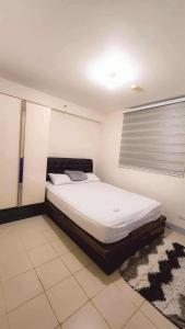 a bedroom with a large bed in a room at Comfy Condo Mactan Cebu in Sampong