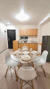 a dining room with a table and chairs and a kitchen at Comfy Condo Mactan Cebu in Sampong +5 photos