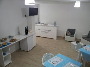 Habitación pequeña con cocina, mesa y sillas. en B&B Le tre Spiagge, en Calasetta