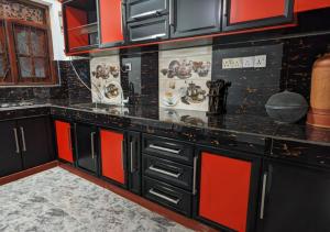 eine Küche mit schwarzen und roten Schränken und einer Theke in der Unterkunft Serenità Moon Villa in Tangalle