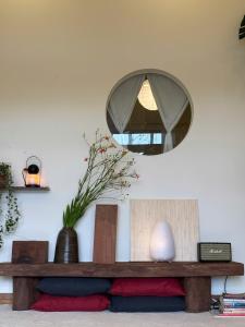 a mirror on a wall above a wooden table at Brownie Home Dalat in Da Lat