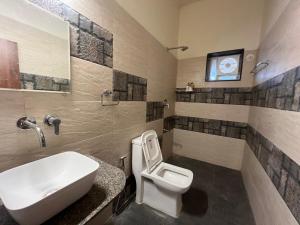 a bathroom with a white sink and a toilet at IRWINA-In rhythm with nature in Pushkar +14 photos