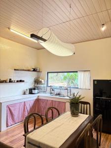 a kitchen with a table with chairs and a light fixture at Brownie Home Dalat in Da Lat