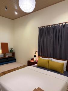 a bedroom with two beds and a large window at Brownie Home Dalat in Da Lat