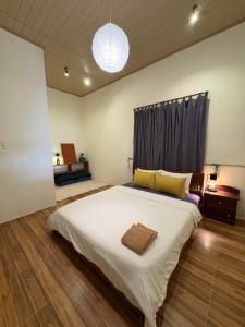a bedroom with a large white bed with a window at Brownie Home Dalat in Da Lat +25 photos