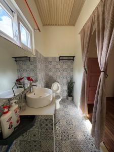 a bathroom with a tub and a toilet and a sink at Brownie Home Dalat in Da Lat
