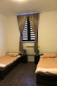 two twin beds in a room with a window at COMBO noclegi pracownicze, dla firm  +21 photos