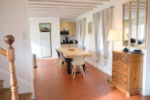 une cuisine et une salle à manger avec une table et des chaises en bois dans l'établissement Le Relais des Hortensias, à La Celle-sous-Gouzon