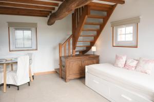 a bedroom with a staircase and a bed and a desk at La Sellerie et Le Relais des Hortensias in Graincourt