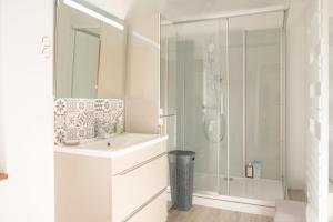 une salle de bain blanche avec une douche et un lavabo dans l'établissement Le Relais des Hortensias, à La Celle-sous-Gouzon 18 autres photos