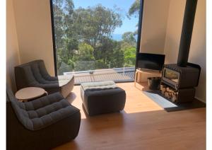 a living room with two chairs and a fireplace at Perch Lorne in Lorne
