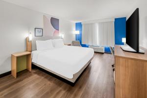 a hotel room with a large bed and a tv at Spark by Hilton in Woodbridge