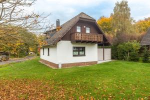 ein Haus mit einer Terrasse auf einem Rasen in der Unterkunft Landhaus Sophie in Frielendorf