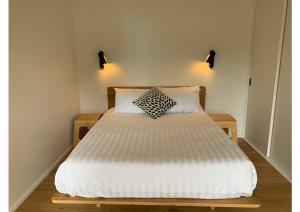 a bedroom with a white bed with two pillows at Perch Lorne in Lorne