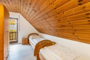 2 Betten in einem Zimmer mit Holzdecke in der Unterkunft Landhaus Sophie in Frielendorf