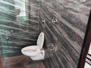 a bathroom with a toilet and a shower at Hotel O AM2PM Restaurant 