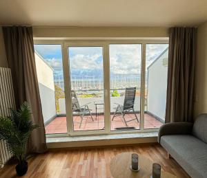 Una sala de estar con una gran ventana con sillas en un patio. en Frisch renoviertes FH Südblick am Meer in Breege, Meerblick von allen drei Etagen, Terrasse, Balkon, Sauna und Parkplatz, en Breege 8 fotos más