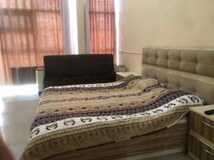a bedroom with a bed with a blanket on it at İzmir can hotel in Baku +1 photo