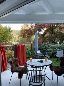 a patio with a table and chairs and a computer at Ferienwohnung Buntspecht in Bad Wildbad