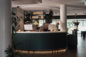 a lobby with a green counter in a building at Home Hotel Kompaniet in Nyköping