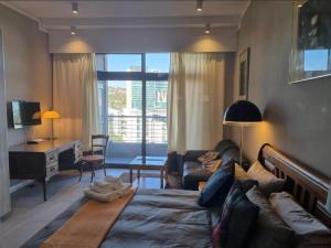 a bedroom with a bed and a couch and a desk at Menlyn Maine Apartments in Pretoria