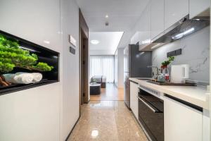 une cuisine avec des comptoirs blancs et un aquarium au mur dans l'établissement Ruilan Courtyard, à Shenzhen