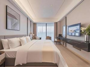 une chambre d'hôtel avec un grand lit et un bureau dans l'établissement Ruilan Courtyard, à Shenzhen