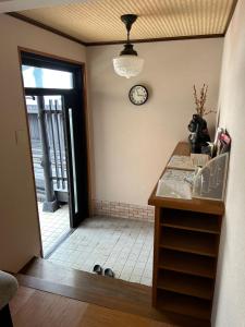 Un pasillo con una puerta y un reloj en la pared. en 白浜の宿梅 別館, en Shirahama