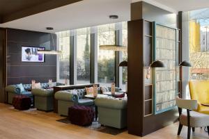 une salle d'attente avec des canapés, des tables et des fenêtres dans l'établissement Premier Inn Hamburg City Zentrum, à Hambourg