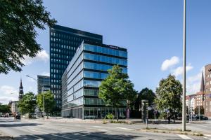 un grand bâtiment de bureau en verre dans une rue de la ville dans l'établissement Premier Inn Hamburg City Zentrum, à Hambourg