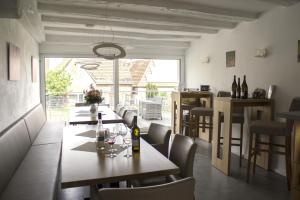a dining room with tables and chairs and a large window at Bioweingut Glaser in Hainfeld