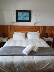 a large white bed with two pillows on it at Pik & Pikkie Self catering apartments in Lambertʼs Bay